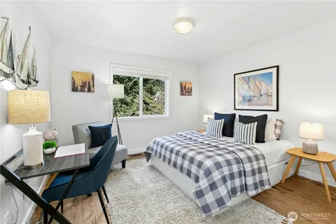 a bedroom with a bed table and a window