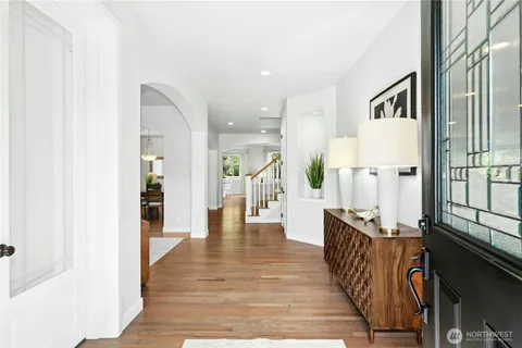 an entryway with wooden floor and windows