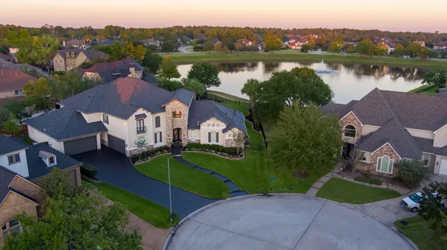 an aerial view of a house with garden space and a lake view