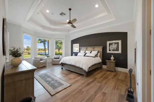 a bedroom with a large bed a couch and potted plant