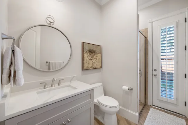 a bathroom with a granite countertop toilet a sink and a mirror