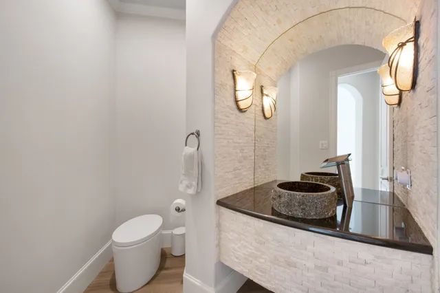 a bathroom with a granite countertop sink a toilet and a mirror