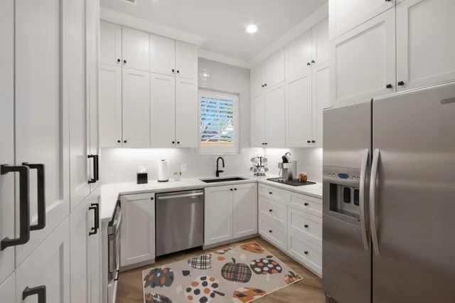 a kitchen with stainless steel appliances a refrigerator sink and cabinets