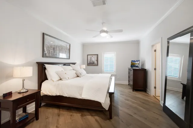a bedroom with a bed painting on wall and a desk