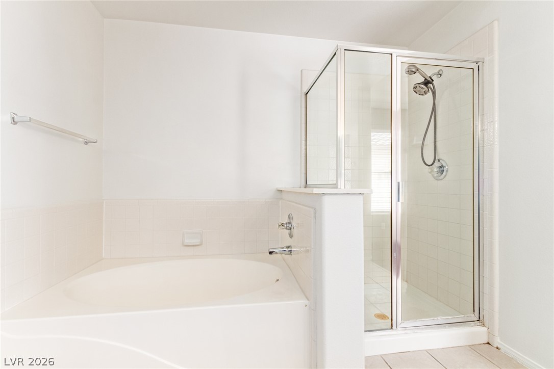 1477 Rancho Ridge Drive Henderson, NV 89012 - Photo 21 of 46 Relax in this well-appointed bathroom featuring a deep soaking tub and a separate glass-enclosed shower.