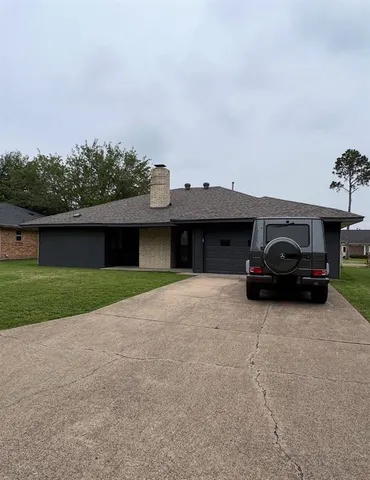 a view of a car parked in back yard of a house