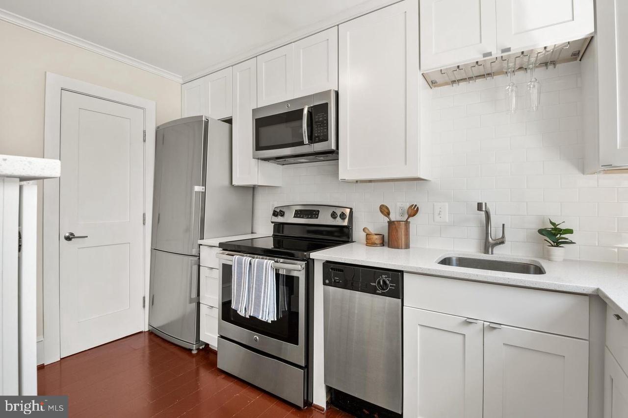 1451 Park Road Northwest, Unit 220 Washington, DC 20010 - Photo 13 of 30 a kitchen with cabinets stainless steel appliances and a counter space
