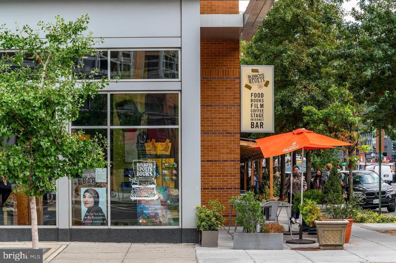 1451 Park Road Northwest, Unit 220 Washington, DC 20010 - Photo 27 of 30 a table and chairs under an umbrella in front of house