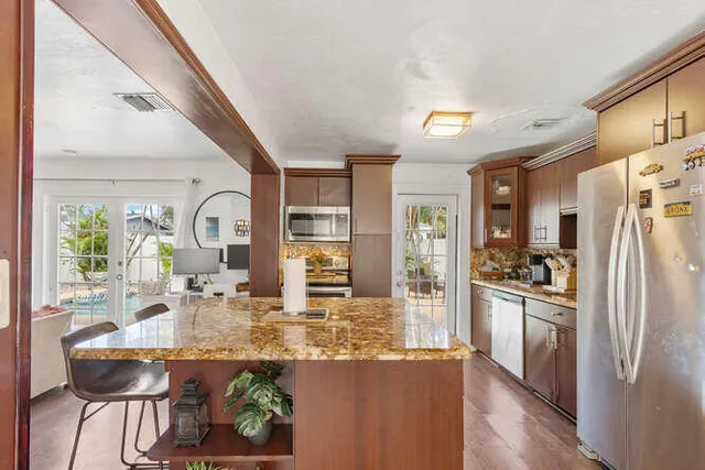 a kitchen with stainless steel appliances granite countertop a refrigerator and a stove
