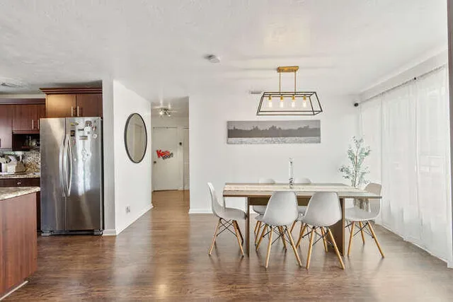 a view of a dining room with furniture a chandelier and wooden floor