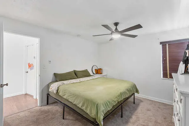 a bedroom with a bed and a ceiling fan