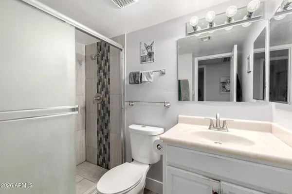 a bathroom with a sink a toilet and shower