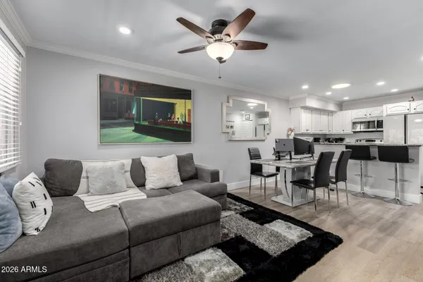a living room with furniture kitchen view and a window
