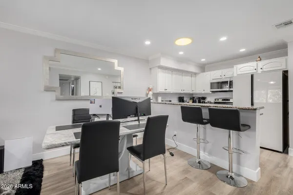 a kitchen with stainless steel appliances kitchen island granite countertop a table and chairs