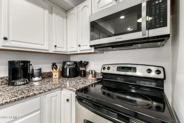 a kitchen with granite countertop a stove and a microwave