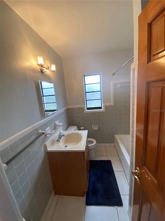 461 South Brevard Avenue, Unit 18 Cocoa Beach, FL 32931 - Photo 11 of 24 a bathroom with a sink a toilet a tub and mirror