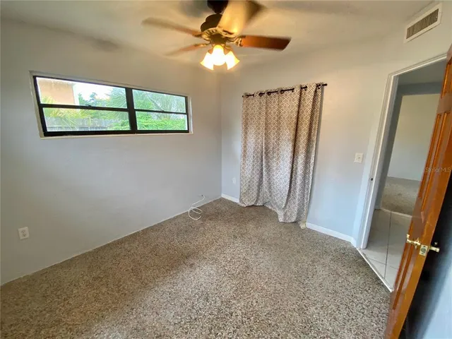 a view of a room with a window and a ceiling fan