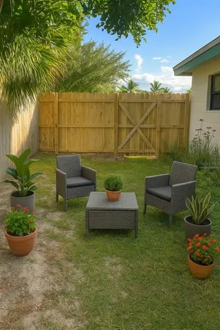 a view of a backyard with couches and a potted plant