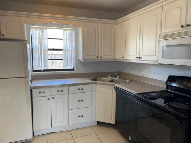 a kitchen with granite countertop white cabinets and sink