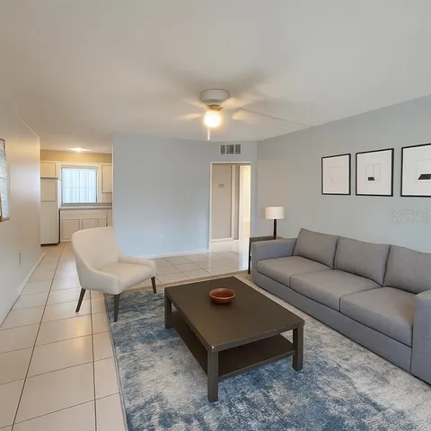 a living room with furniture and a potted plant