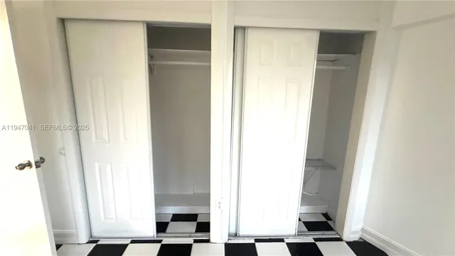 a view of a big room with wooden floor and windows