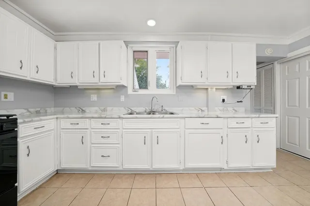 a kitchen with granite countertop white cabinets and white appliances