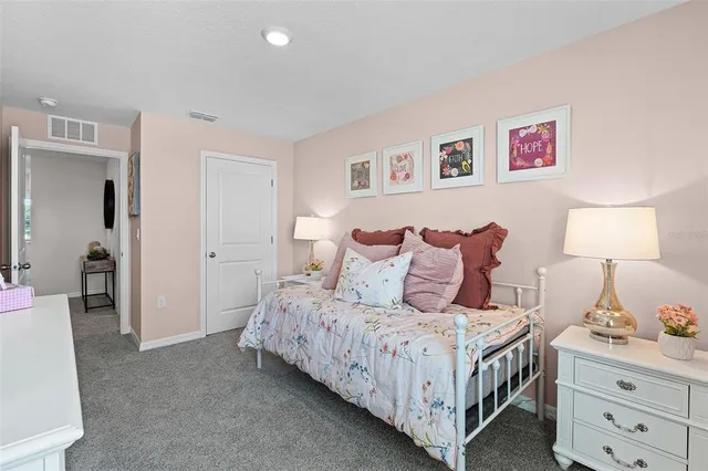 a bedroom with a bed and a lamp on dresser