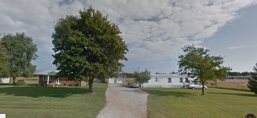 166 Sixteenth Model Road Manchester, TN 37355 - Photo 1 of 17 a view of a white house next to a yard with big trees