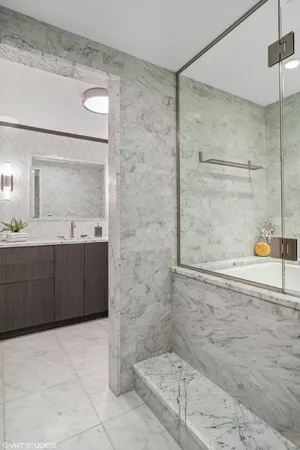 a bathroom with a granite countertop sink a mirror and shower