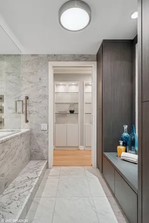 a bathroom with a tub shower sink and mirror