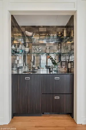 a room with stainless steel appliances wooden cabinet and view of kitchen