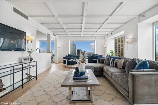 a living room with furniture a wooden floor and a chandelier
