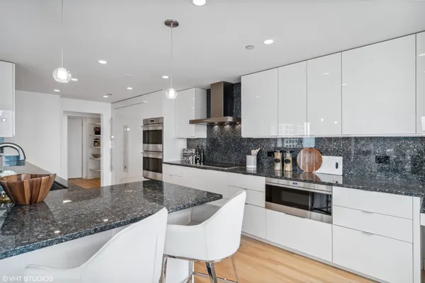 a kitchen with stainless steel appliances granite countertop a sink and a stove top oven