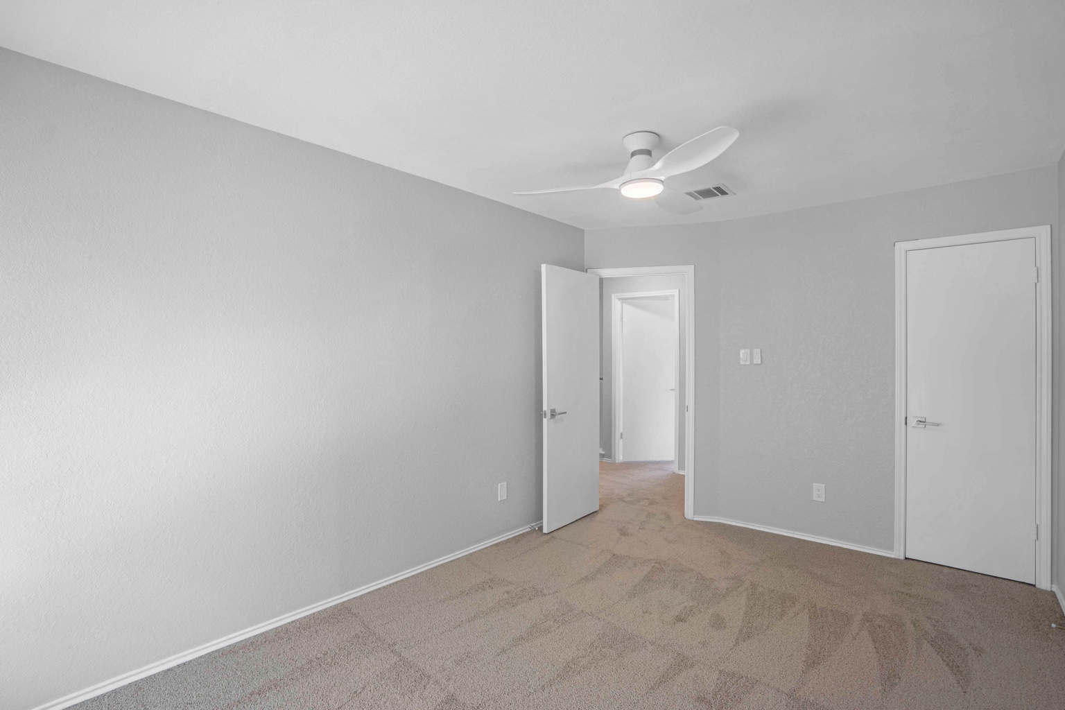 800 Smoke Signal Pass Pflugerville, TX 78660 - Photo 12 of 40 A comfortable bedroom with soft carpet flooring and a modern ceiling fan for optimal airflow.