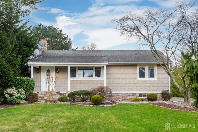 a front view of a house with a yard and green space