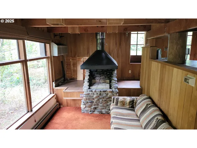 a living room with furniture a large window and wooden floor
