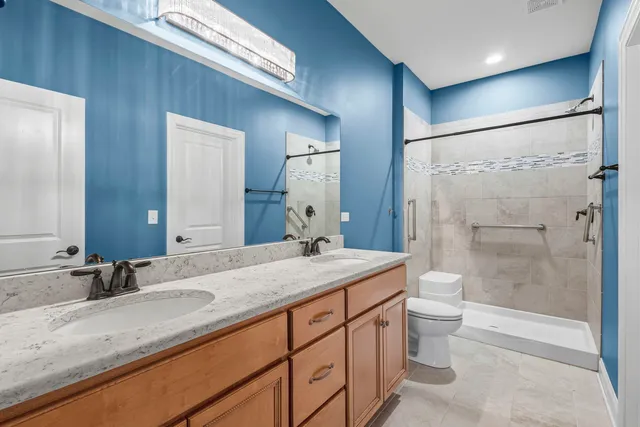 a bathroom with a granite countertop sink mirror vanity and toilet