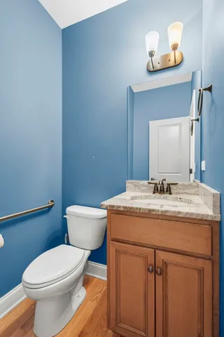 a bathroom with a granite countertop toilet sink and mirror