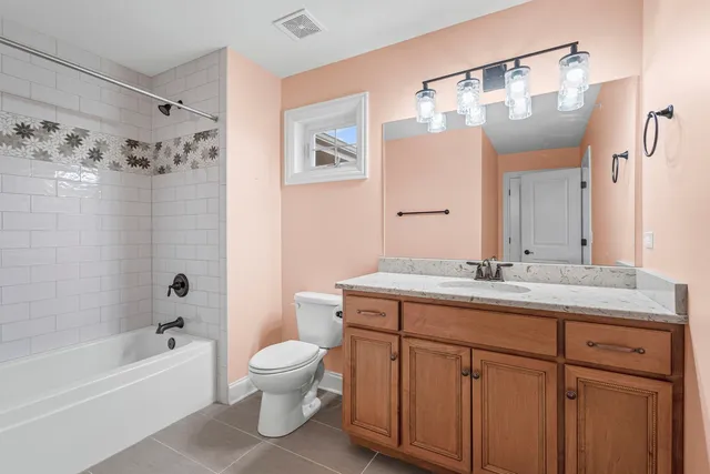 a bathroom with a granite countertop sink a toilet a large mirror and shower