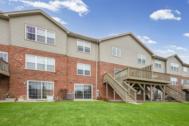 a front view of a house with a yard and green space
