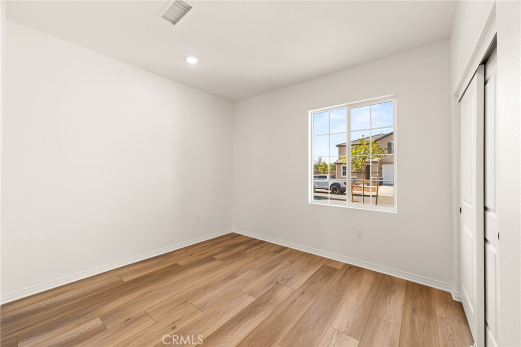 19434 Arenal Way Riverside, CA 92508 - Photo 13 of 25 an empty room with wooden floor and windows