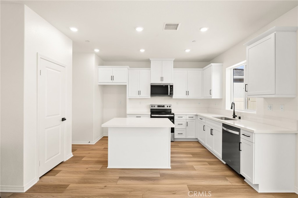 19434 Arenal Way Riverside, CA 92508 - Photo 6 of 25 a large kitchen with stainless steel appliances
