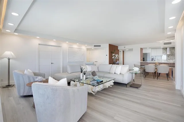 a living room with couches and a dining table with kitchen view