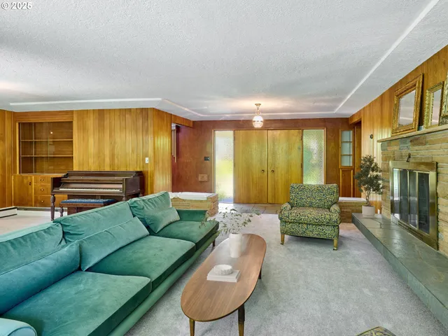 a living room with furniture a fireplace and a large window
