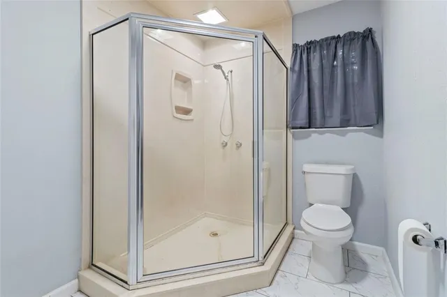 a bathroom with a shower a toilet and a sink
