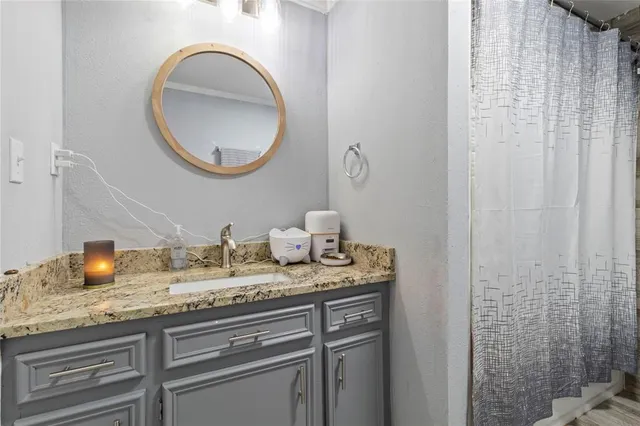 a bathroom with a granite countertop sink and a mirror