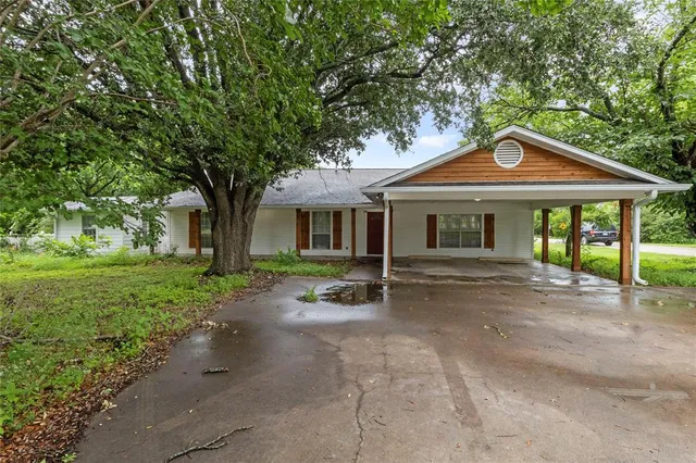 a front view of a house with yard and green space