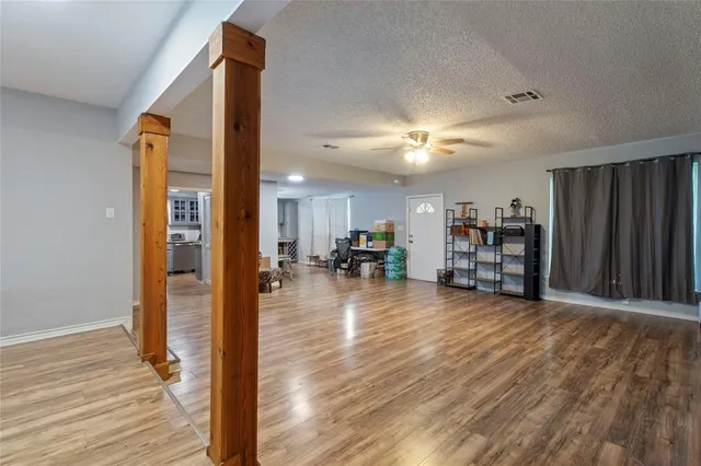 a view of a living room and kitchen view with wooden floor
