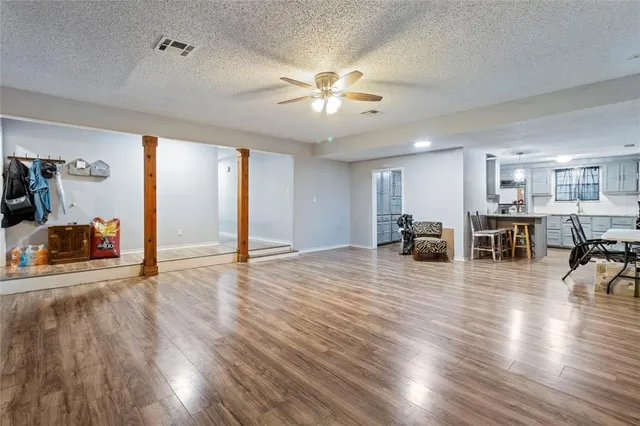 a view of a livingroom with furniture wooden floor ceiling fan and windows