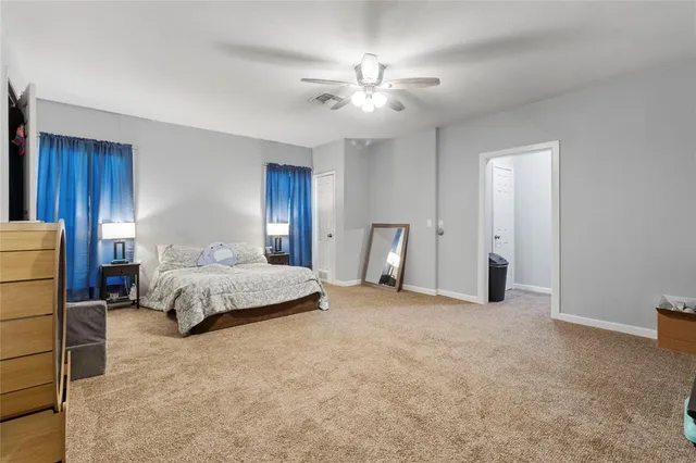 a spacious bedroom with a bed and a chandelier